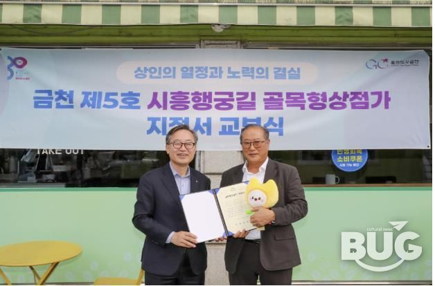 유성훈 금천구청장(왼쪽)과 김명식 상인회장이 골목형상점가 지정서 교부식을 진행하고 기념촬영을 하고 있다