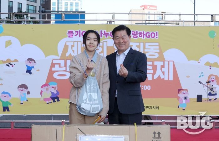 박승원 광명시장이 지난 1일 일직동 새빛공원로 차 없는 거리에서 열린 ‘제3회 일직동 광명새빛축제’에 참석해 상품을 전달하고 기념사진을 촬영하고 있다,